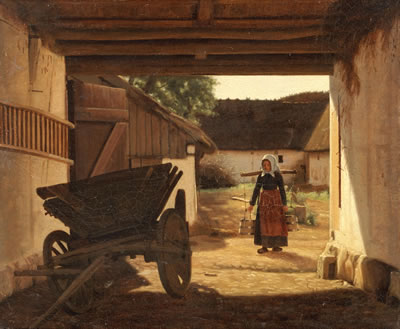 Young milk maid walking through a farm gate