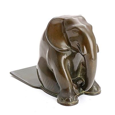 A patinated “disko” metal book end cast with a sitting elephant.