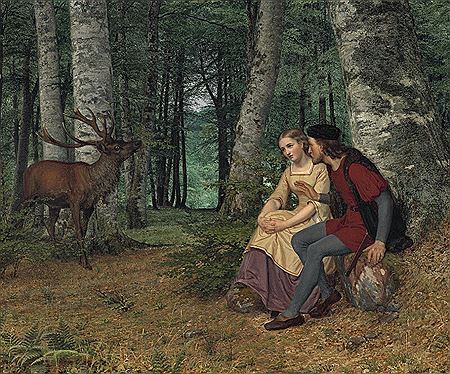 A young couple sitting in a forest.