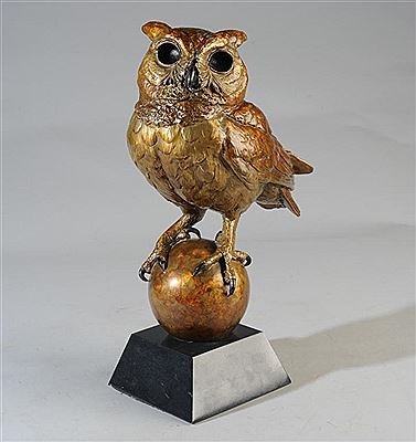 Horned owl perched on an orb, full of life and presence