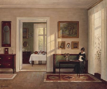 An interior with a woman sitting on a sofa.