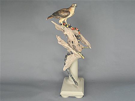 Full size red tail hawk on wooden base
