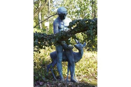 Young man with young deer / idyllic forest