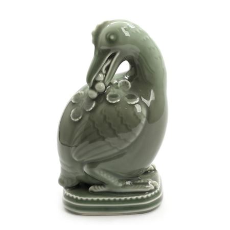 A white stoneware figure modelled in the shape of a bird.