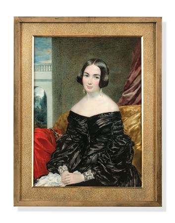 Woman in a black dress seated on a sofa