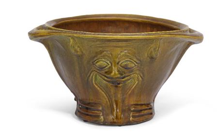 An earthenware bowl modelled with two faces and two openwork handles