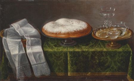 A lace-trimmed hand cloth, a pan dulce and glassware on a stand, all arranged upon a tabletop draped with green damask