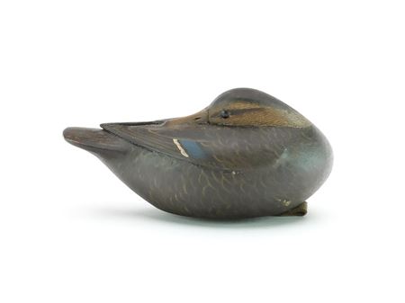 Miniature sleeping black duck with relief wing carving and slightly raised wing tips.