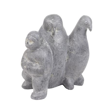 A LARGE INUIT SOAPSTONE FIGURAL GROUP OF A MAN WITH TWO STANDING BIRDS