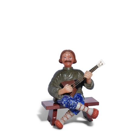 FIGURE OF A RUSSIAN BALALAIKA PLAYER ON A BENCH