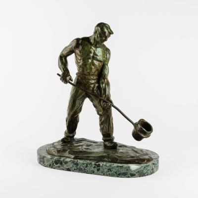 A bronze sculpture of a man casting bronze