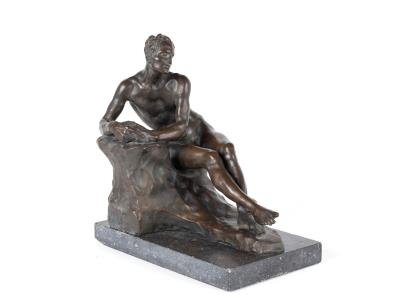 Seated nude man leaning on a rock