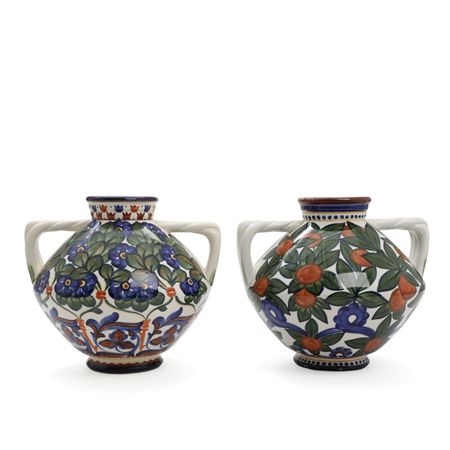 Two faience vases with paired handles, decorated in colours with flowers and fruit.