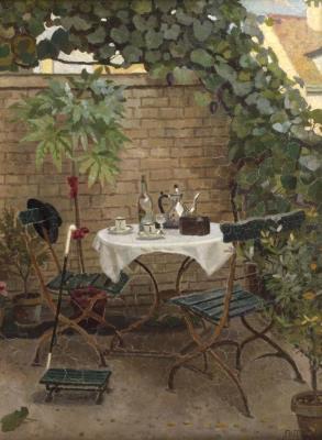 Garden scene – romantic summer view of a garden wall with a laid table and climbing plants