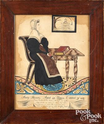 Interior portrait of Mary Stevens, seated at a table with book and memorial to David Stevens hanging on the wall