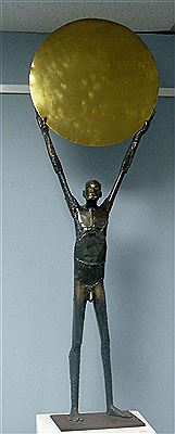 Male nude, standing and holding a large disc above his head