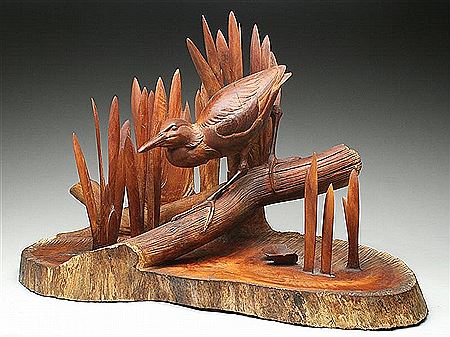 Large carving of a night heron on a log in the marsh