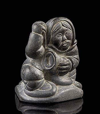 Carving of an Inuk making mukluks