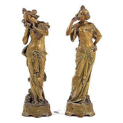 Suite de deux grands sujets en porcelaine à double patine dorée brillant et mat, à reflets verts, représentant chacun une femme Art Nouveau, ornements végétaux et nénuphars, terrasses ornées de visages de femmes (2)