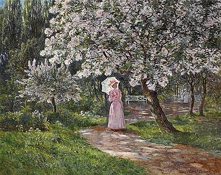 A lady in pink standing under a flowering cherry tree.