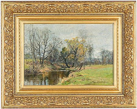 A creek with mostly leafless trees along the bank, presumably during late autumn