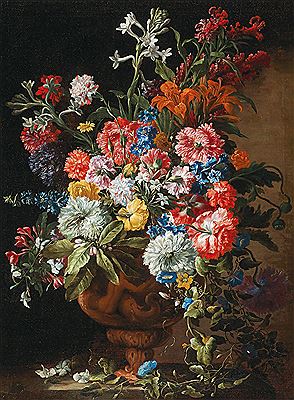 Carnations, lillies, nigellas and other flowers in a decorative terracotta vase on a stone ledge