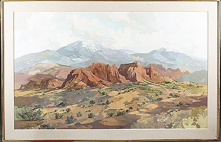 A South Western US landscape with red rocks in front of white capped mountains