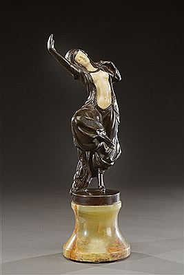 Epreuve chryséléphantine en bronze à patine brune et ivoire figurant une danseuse russe. Elle repose sur une base tronconique concave en onyx vert nuancé brun