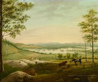 Cows grazing on a hillside with a view of a lake and farmhouse