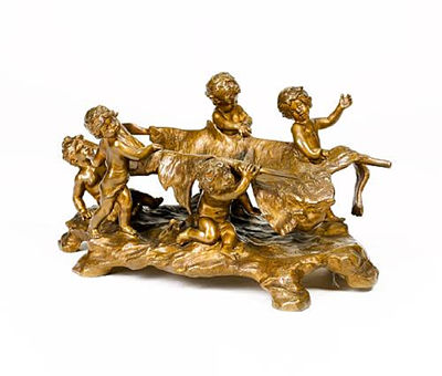 A bronze figural group of five putto supporting a lion skin stretcher on a naturalistic rocky base