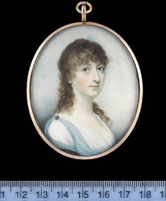 A Lady, wearing Classical inspired robes, white muslin dress with pale blue robe pinned at her shoulder with brooch, a dark blue cloak over her right arm, her hair worn long and curled.
