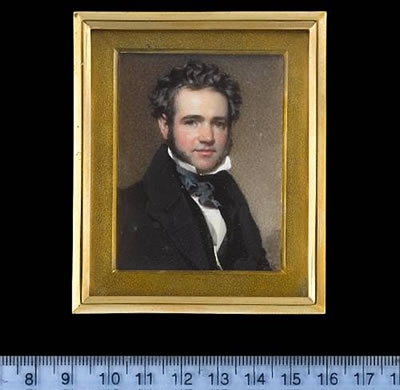 A Gentleman, wearing black coat, black waistcoat, white chemise with standing collar and dark blue cravat
