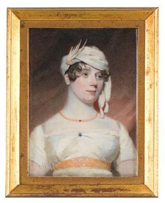 Lady Lacon, wearing white dress, gold waistband, blue pin at her corsage, gold necklace and white turban.