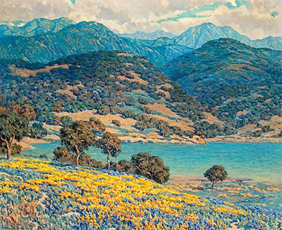 Poppies and lupine by a lake with mountains in the distance
