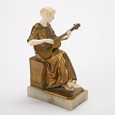 A 20th century gilt bronze and ivory figurine, depicting a guitar playing woman