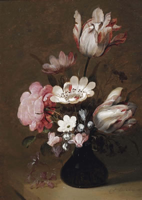 A glass vase with tulips, peonies and other flowers on a stone ledge