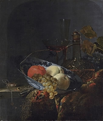 Grapes, peaches and an orange in a porcelain bowl, with a watch, nuts, a knife, a glass decanter, wine-glasses, grapes and a carpet on a wooden table