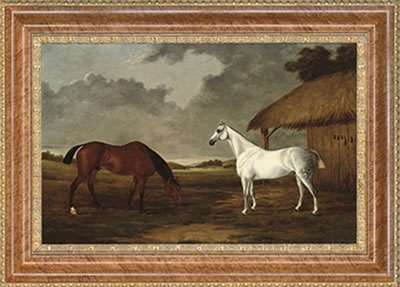 A bay and a grey horse grazing beside a stable