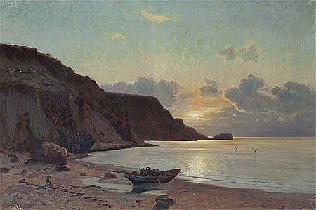 A boat on the shore at sunset