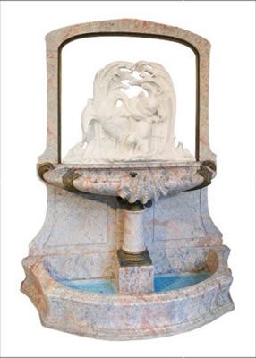 Sculpture of swans, a child, a frog and dragonfly on top of a fountain