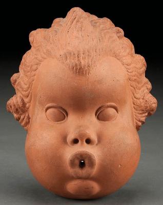 Puttos face finely modeled form with pierced lips possibly functioning as a string holder