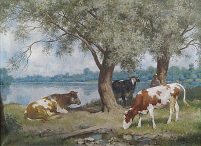 Cows under trees at lakeshore