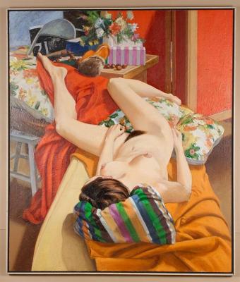 Nude woman reclining on a sofa and with a striped pillow