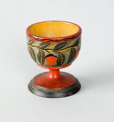 Turned and painted egg cup with strawberry decoration on a blue ground