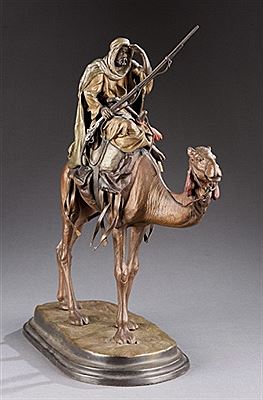 A man riding a camel, looking out over the horizon