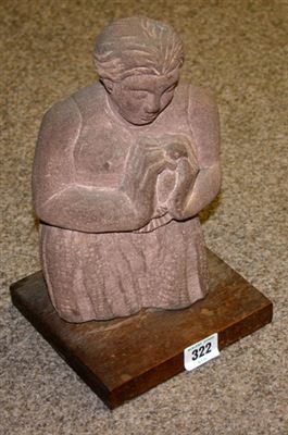 Pennant slate sculpture mounted to wooden base; figure clasping a bird to their breast