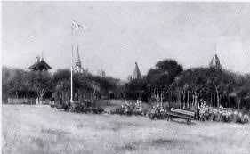 View of Park with Man Picking Flowers