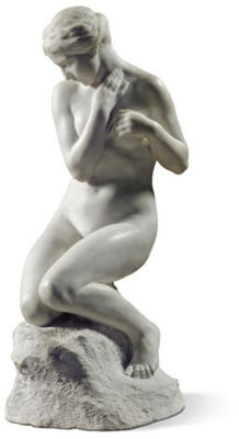 A FEMALE NUDE KNEELING ON A ROCK