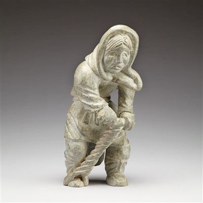 WOMAN WEARING AN AMUATI WITH AN ICE AUGER