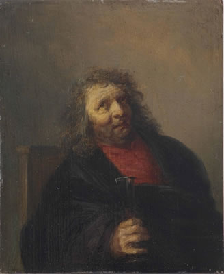 A bearded man seated in a chair drinking